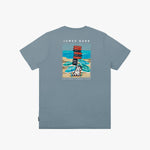 Back view of a gray t-shirt featuring a colorful beach scene illustration. The design includes a dog holding a sign that says 'Bark Loud!' with umbrellas and a beach backdrop. The text 'James Bark' is printed above the design, along with 'Positano Summer Vibes' below the illustration.