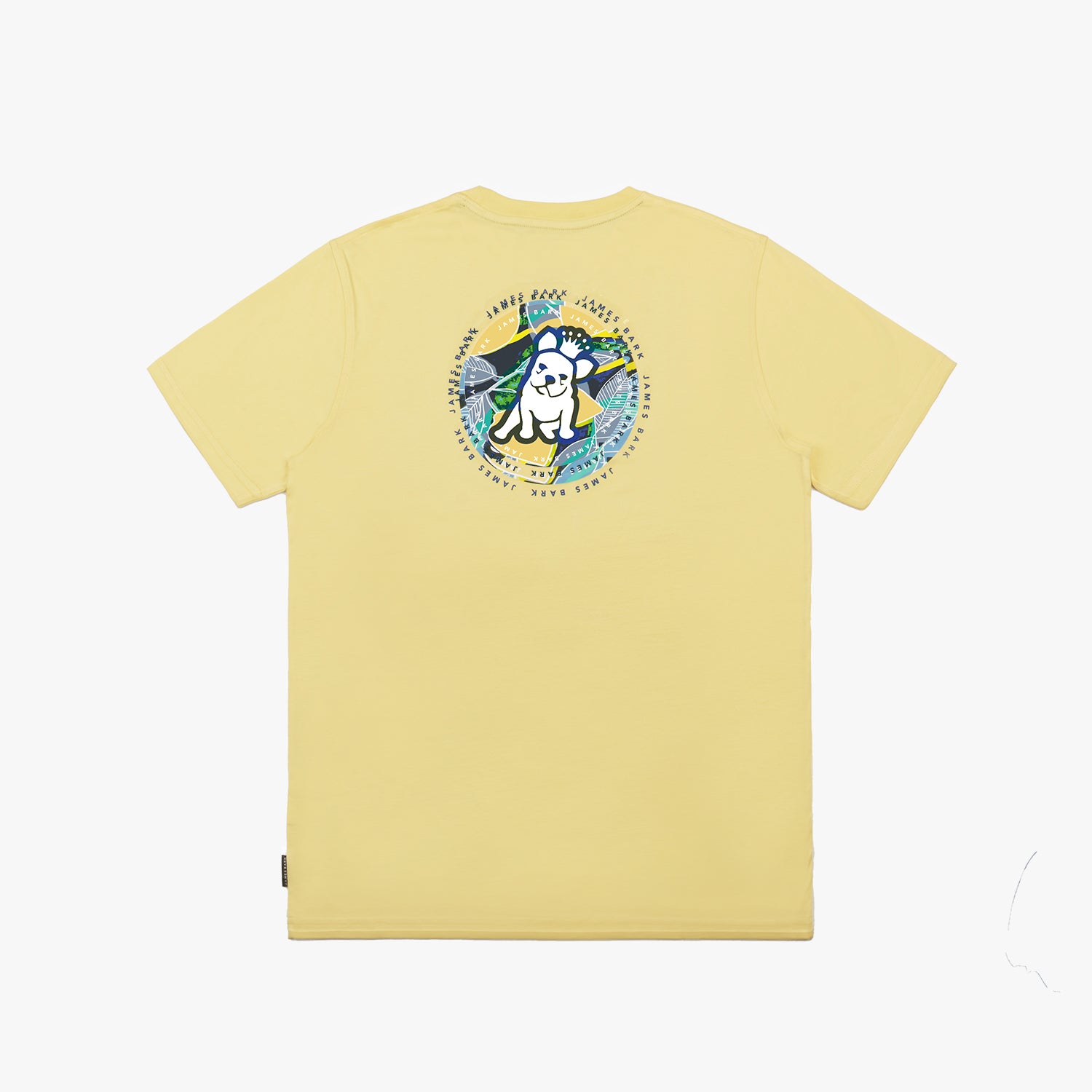 A flat lay of the back of the yellow T-shirt, showing the large circular graphic with the tropical background and dog illustration, along with "James Bark Privé Society" text.