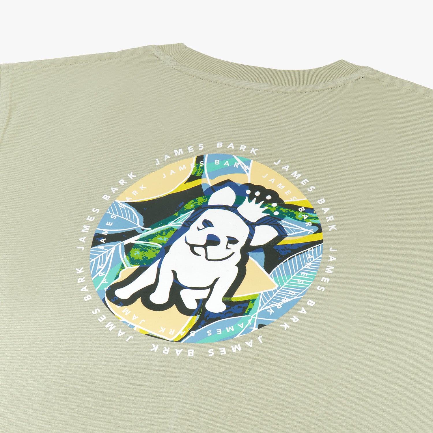 A close-up of the back design on the light green T-shirt, showing the large circular graphic with the dog and tropical background, along with "James Bark Privé Society" text around the circle.