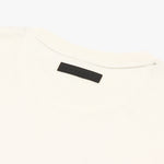 Close-up of the back of a white T-shirt featuring a black rectangular label with embossed text that reads 'James Bark,' positioned at the neckline, displayed on a plain white background." Let me know if you'd like any changes