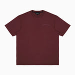 A plain maroon T-shirt displayed flat with a subtle embossed 'James Bark Elements' logo on the chest and a black inner label that reads 'James Bark Elements.' The T-shirt is showcased on a plain white background." Let me know if you'd like to refine this description