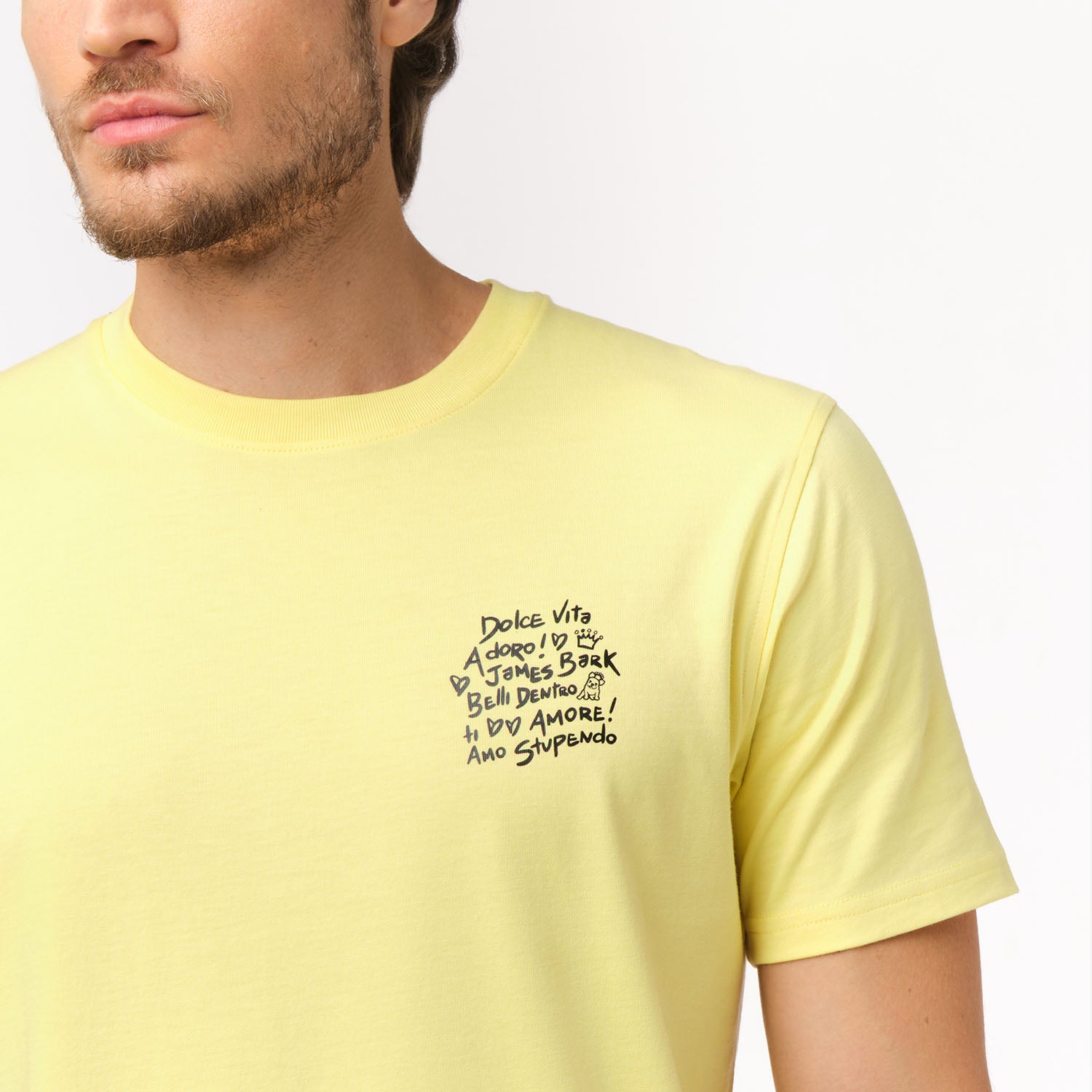 Close-up of the yellow t-shirt's left chest, showing the black graphic design