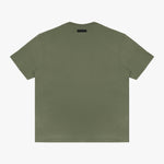 Full-body shot of the model wearing the olive green t-shirt, standing casually with one hand in his pocket.