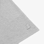 Zoomed-in shot of the gray t-shirt’s fabric, focusing on the subtle logo embroidered onto the sleeve.