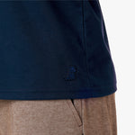 In the second image, a close-up of the lower part of the T-shirt reveals a small embroidered lion logo near the hem, adding a subtle and elegant detail.