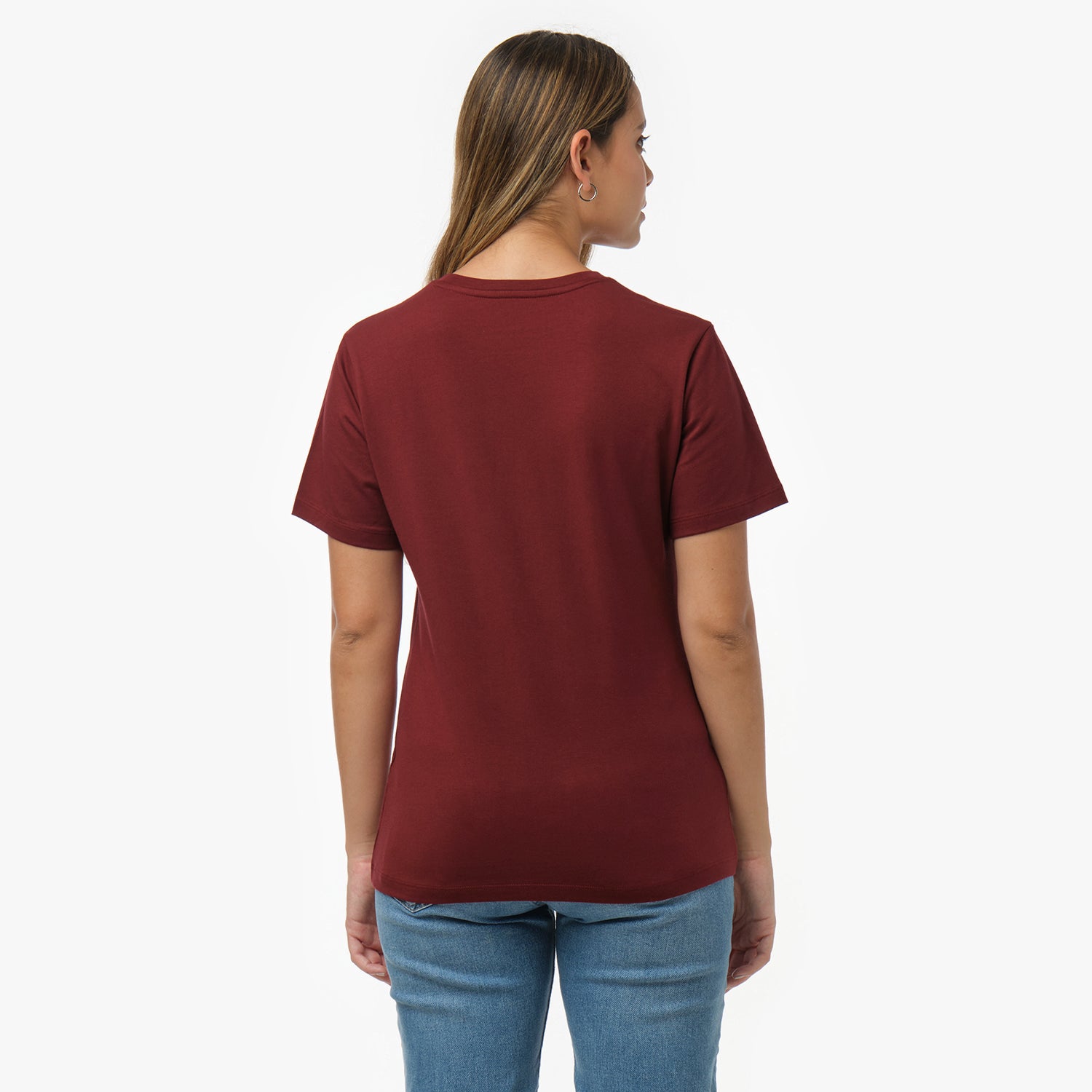 Back view of a woman wearing a plain maroon t-shirt and blue jeans
