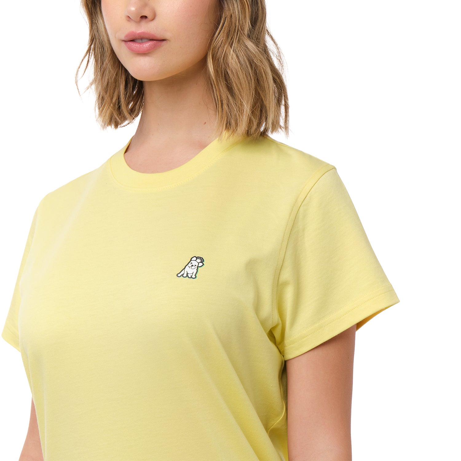 A close-up of the woman wearing the yellow T-shirt, focusing on the chest area with the small embroidered dog logo.