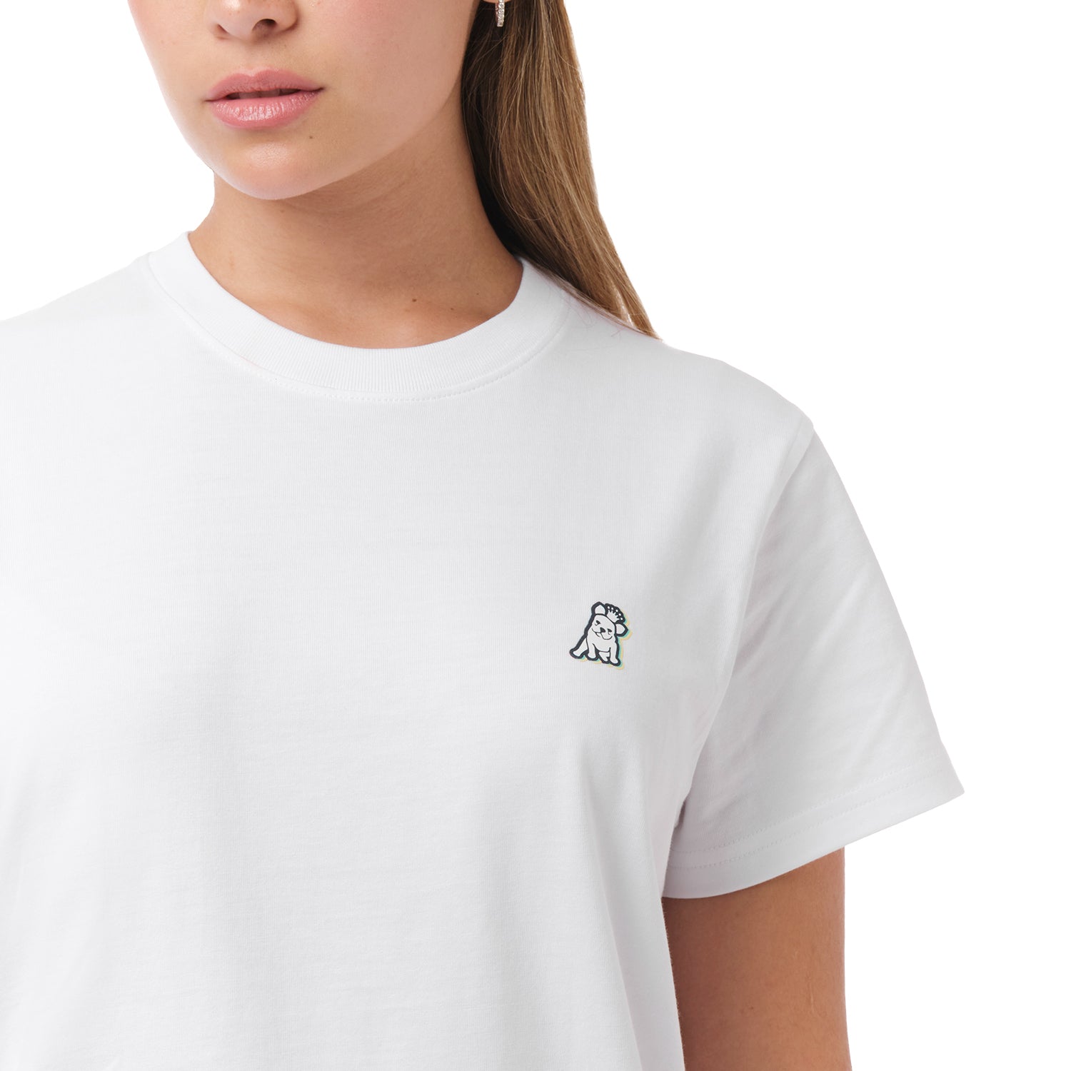 A close-up of the woman wearing the white T-shirt, focusing on the chest area with the small embroidered dog logo.