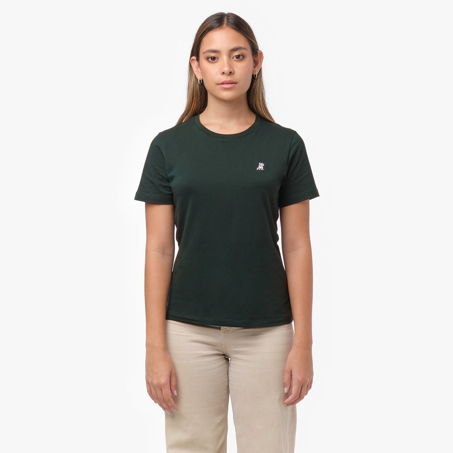 Woman facing forward wearing a dark green t-shirt with small white embroidered dog logo on left chest and beige wide-leg pants