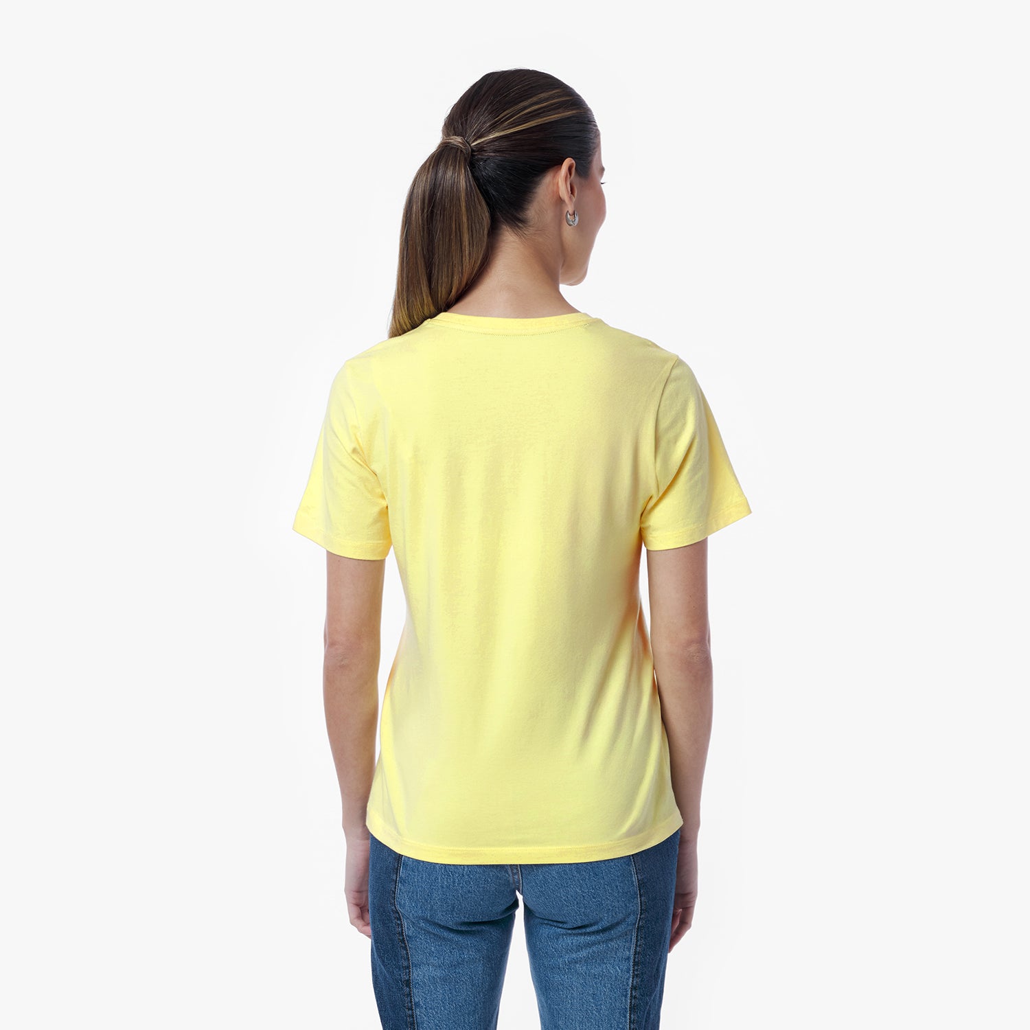 Back view of a woman wearing a yellow t-shirt and blue jeans against a white background