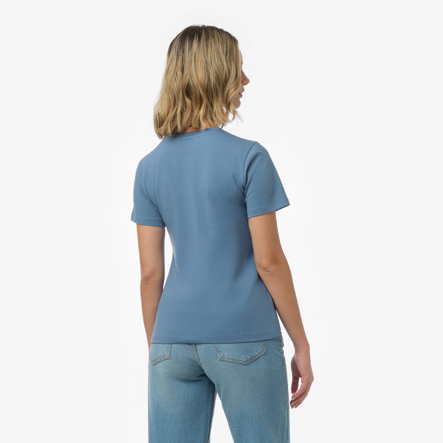 Back view of a woman wearing a plain dusty blue t-shirt and blue wide-leg jeans