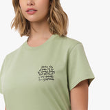 A close-up of the woman wearing the light green T-shirt, focusing on the chest area and the black text design.