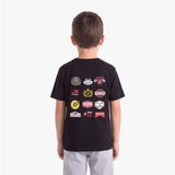 A child viewed from behind, wearing a black T-shirt with a collage of racing-themed patch graphics on the back
