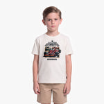 A young boy modeling a cream-colored T-shirt with a James Barker racing graphic