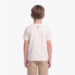 A child viewed from the back wearing a light cream T-shirt with a small black graphic on the upper back
