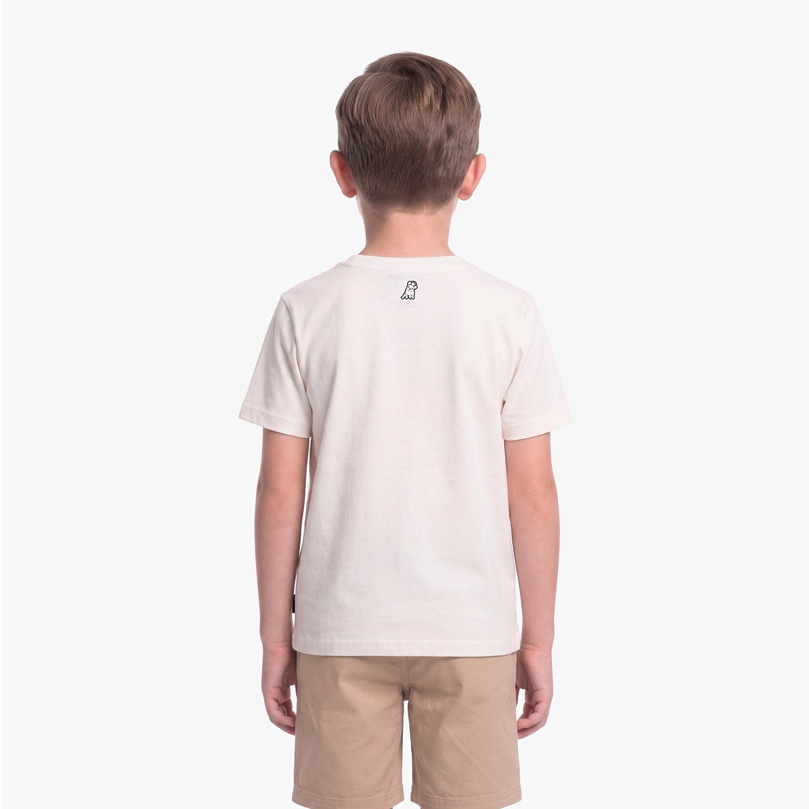 A child viewed from the back wearing a light cream T-shirt with a small black graphic on the upper back