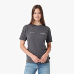 A woman modeling a dark gray short-sleeve t-shirt with white printed text on the chest