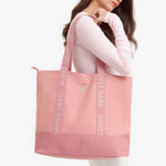 Pink tote bag with 'James Bark' branding held by a person on a white background