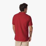 Back view of a man wearing a red polo shirt on a white background