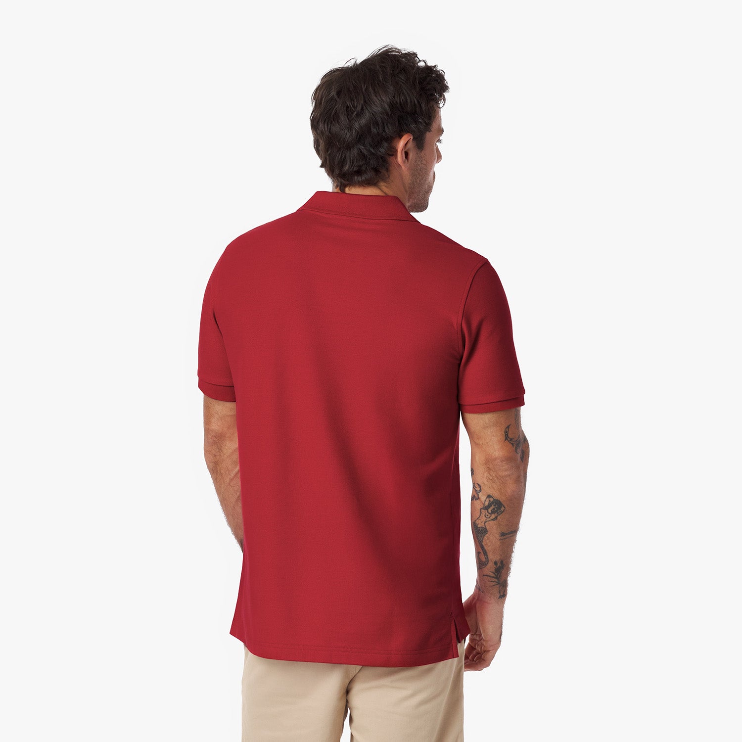 Back view of a man wearing a red polo shirt on a white background