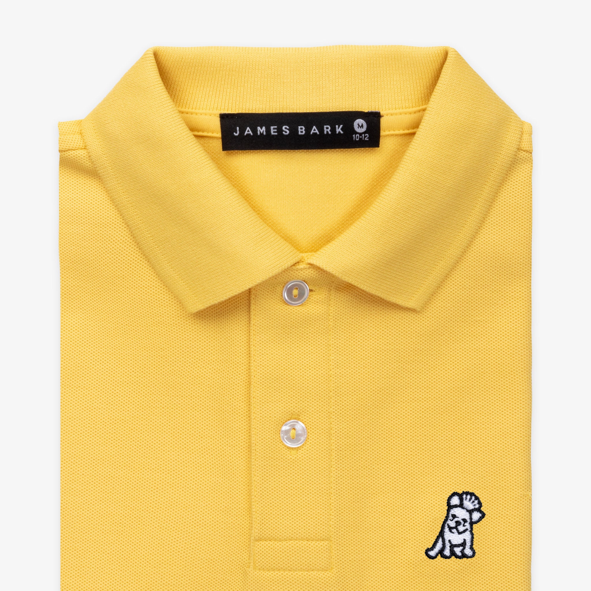 Close-up of the collar and chest area of the yellow polo shirt, showing the button placket and embroidered logo.