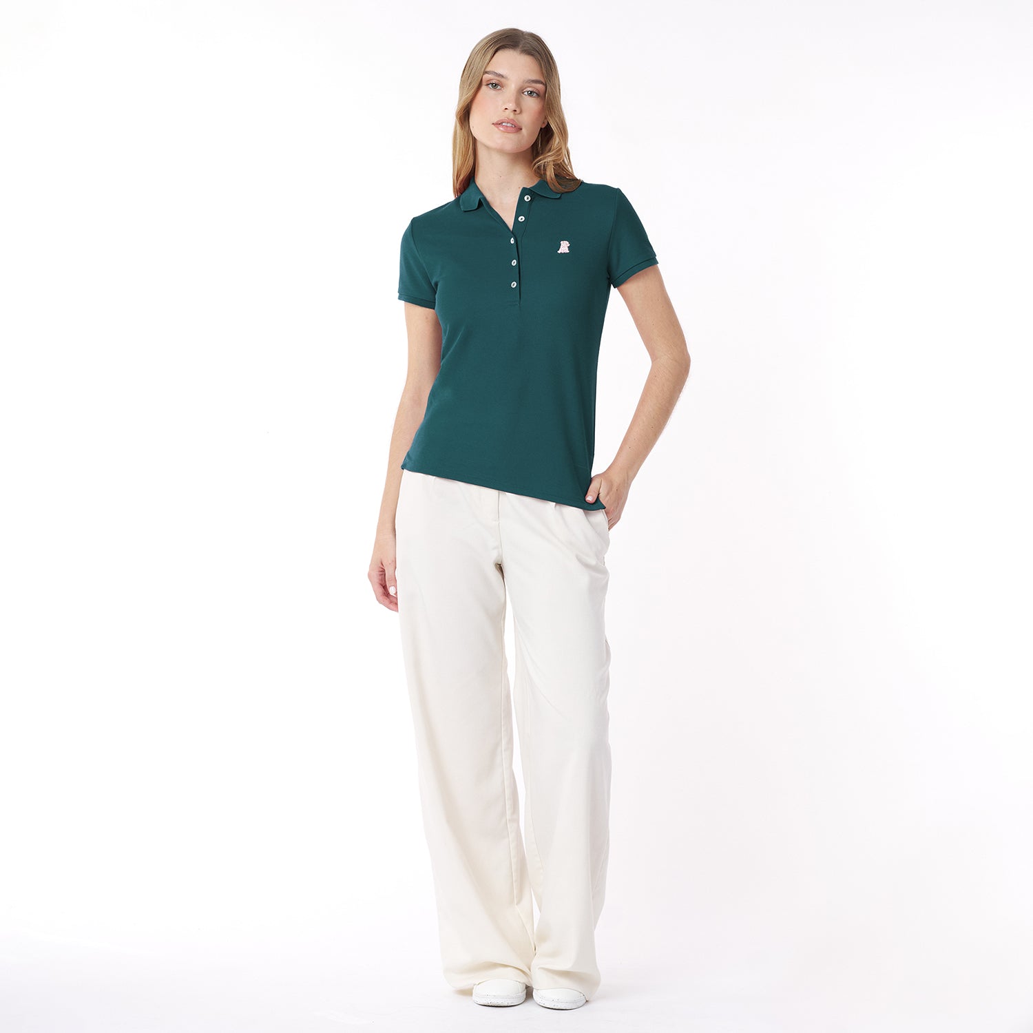 Full body picture of a woman wearing a green polo shirt and white pants on a white background