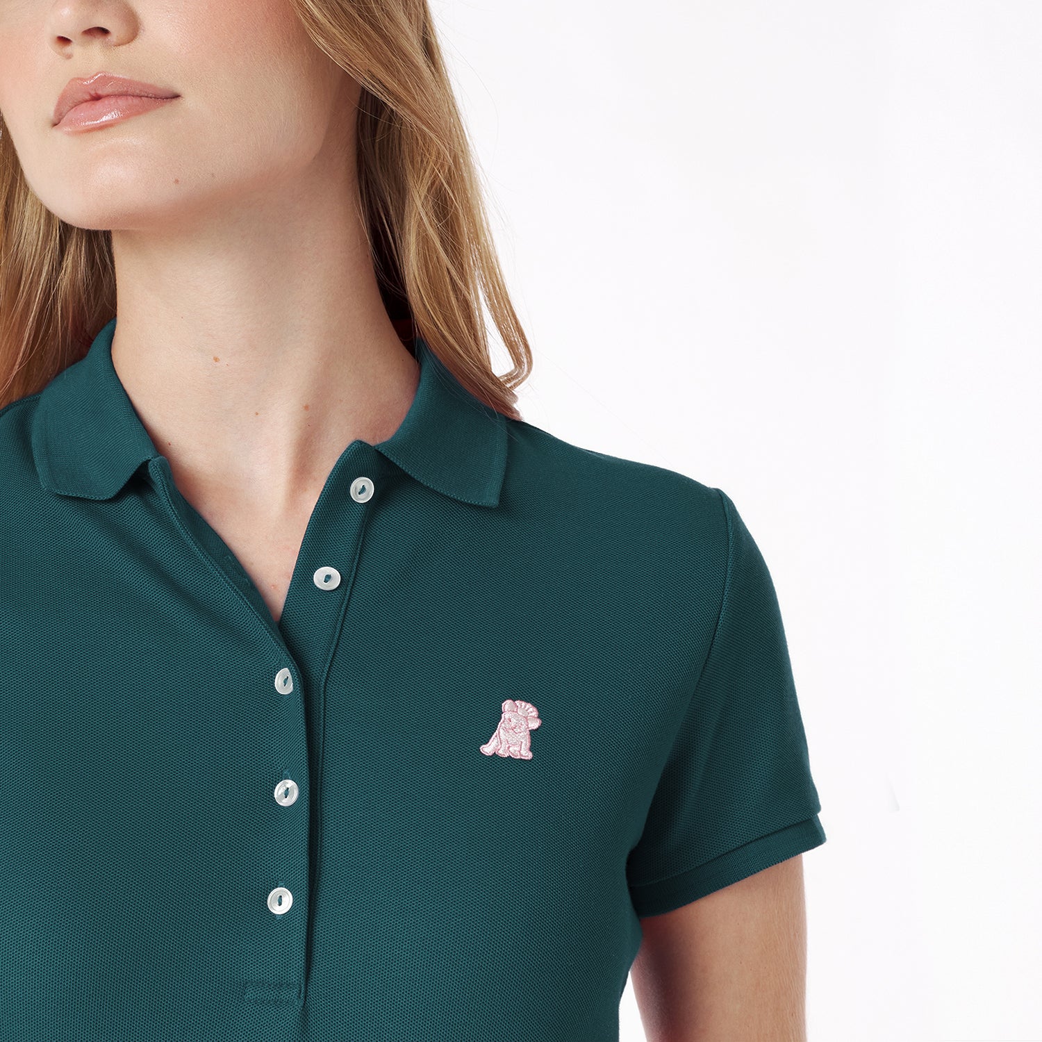 Close-up of a green polo shirt with a small embroidered logo on a white background