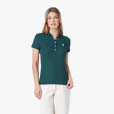 Woman wearing a teal polo shirt with a logo on a white background