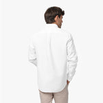Back waist-up view of a male model wearing a white long-sleeve oxford shirt with a back pleat, paired with beige trousers