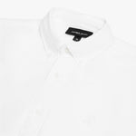 Close-up view of the collar and chest area of a white James Bark oxford shirt, showing the button-down collar, placket buttons, brand label, and the subtle white embroidered dog logo