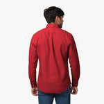 Back waist-up view of a male model wearing a red long-sleeve oxford shirt with a back pleat, paired with dark wash jeans