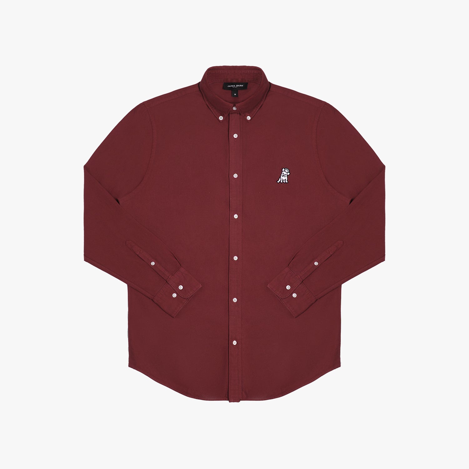 Front view of a maroon long-sleeved button-down shirt laid flat against a white background. It features a button-down collar, buttoned cuffs, white buttons, and a black-and-white embroidered dog logo on the left chest