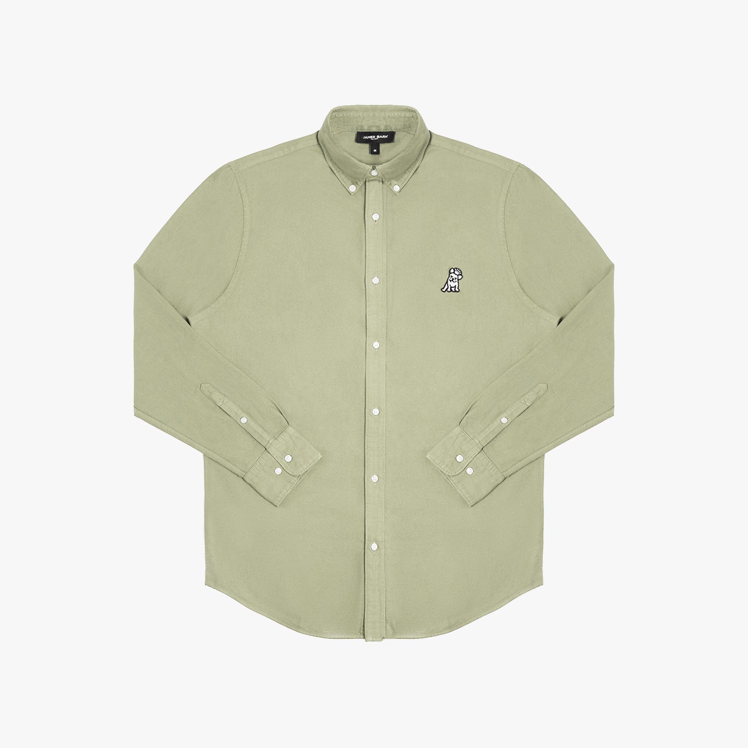 Front view of a sage green long-sleeved button-down shirt laid flat against a white background. It features a button-down collar, buttoned cuffs, white buttons, and a black-and-white embroidered dog logo on the left chest