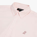 Close-up of the collar and upper chest area of a light pink button-down shirt. Features include a button-down collar, white buttons, a black "JAMES BARK" brand tag, and a tonal pink embroidered dog logo on the left chest