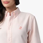 Close-up detail of the light pink oxford shirt collar and chest area, showing the button-down collar, buttons, fabric texture, and the small pink embroidered dog logo on the left chest