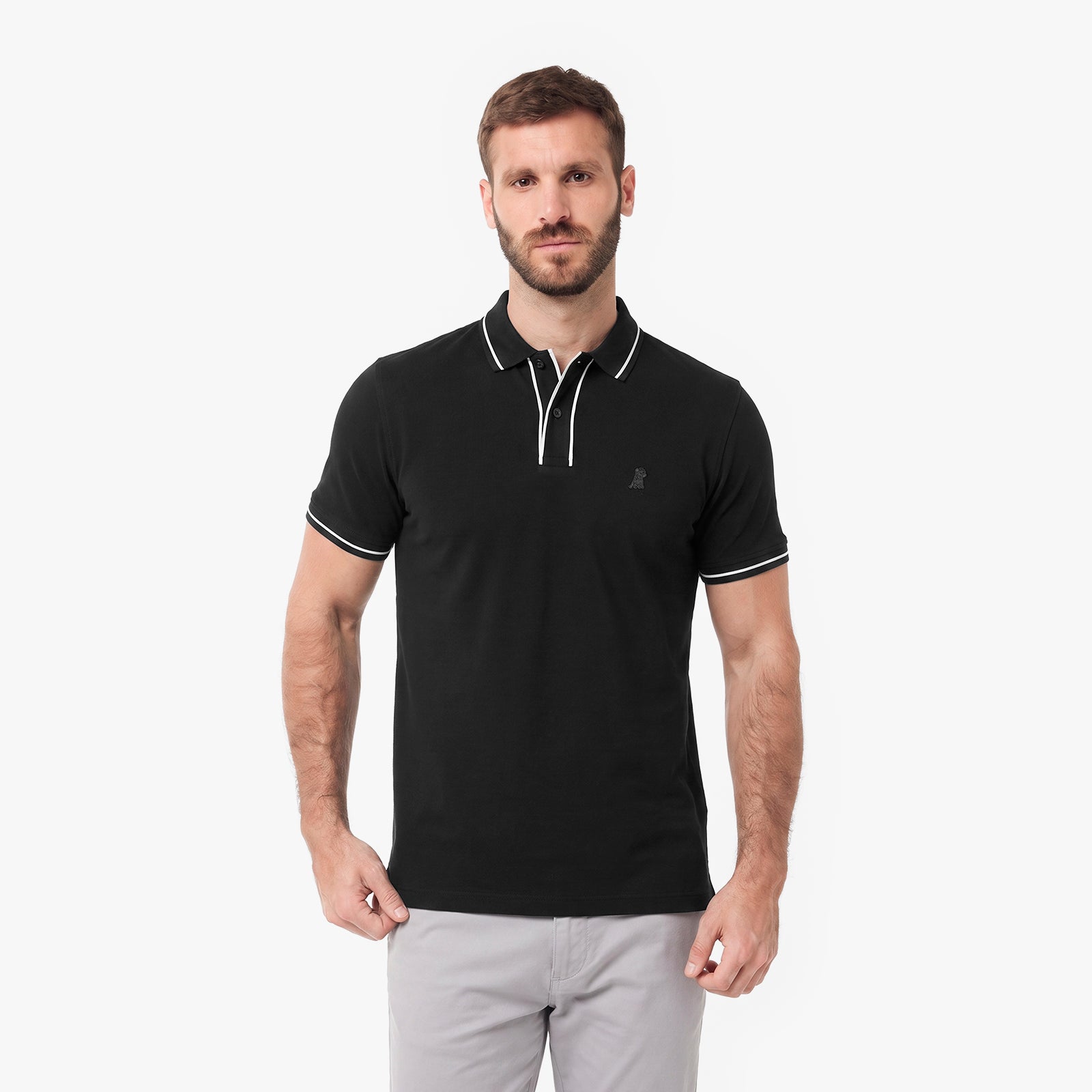 A man wearing a black short-sleeve polo shirt with white piping on the collar and sleeve cuffs