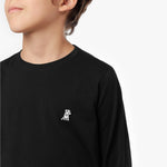 Close-up of a small embroidered white dog logo on a black long-sleeved t-shirt