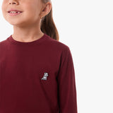 Close-up of the chest area of the burgundy shirt, featuring the small embroidered logo.