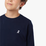 Close-up of a small embroidered light-colored dog logo on a navy long-sleeved t-shirt