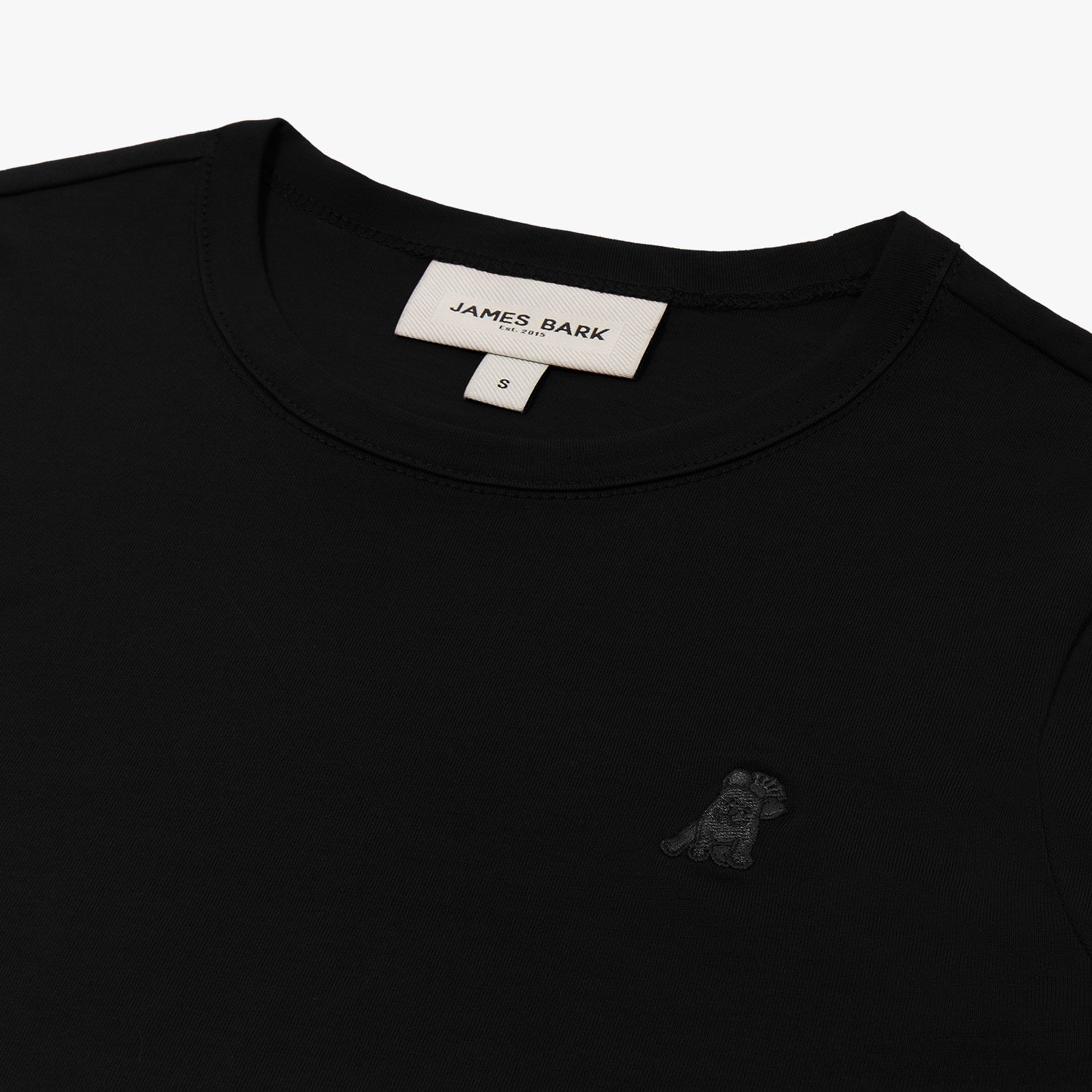 Close-up of the neckline and small dog graphic on the chest of the black long-sleeve shirt.