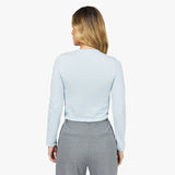 Back view of a woman wearing the light blue long-sleeve shirt.