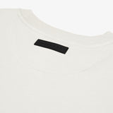 Close-up of the back of a white t-shirt, highlighting a black rectangular 'JAMES BARK' label near the neckline. The fabric appears soft with a ribbed collar and a minimalist aesthetic. White background