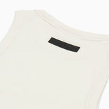 Close-up of the back of a white ribbed tank top, highlighting a black rectangular 'JAMES BARK' label near the neckline. The fabric has a textured ribbed pattern with reinforced stitching along the edges. White background