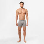 A man standing upright, modeling gray James Bark boxer briefs. The waistband of the boxer briefs features the 'JAMES BARK' branding, and the fabric is form-fitting, highlighting the comfort and fit of the product.