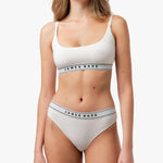 Close-up of the woman’s torso, highlighting the white bralette and waistband detail.