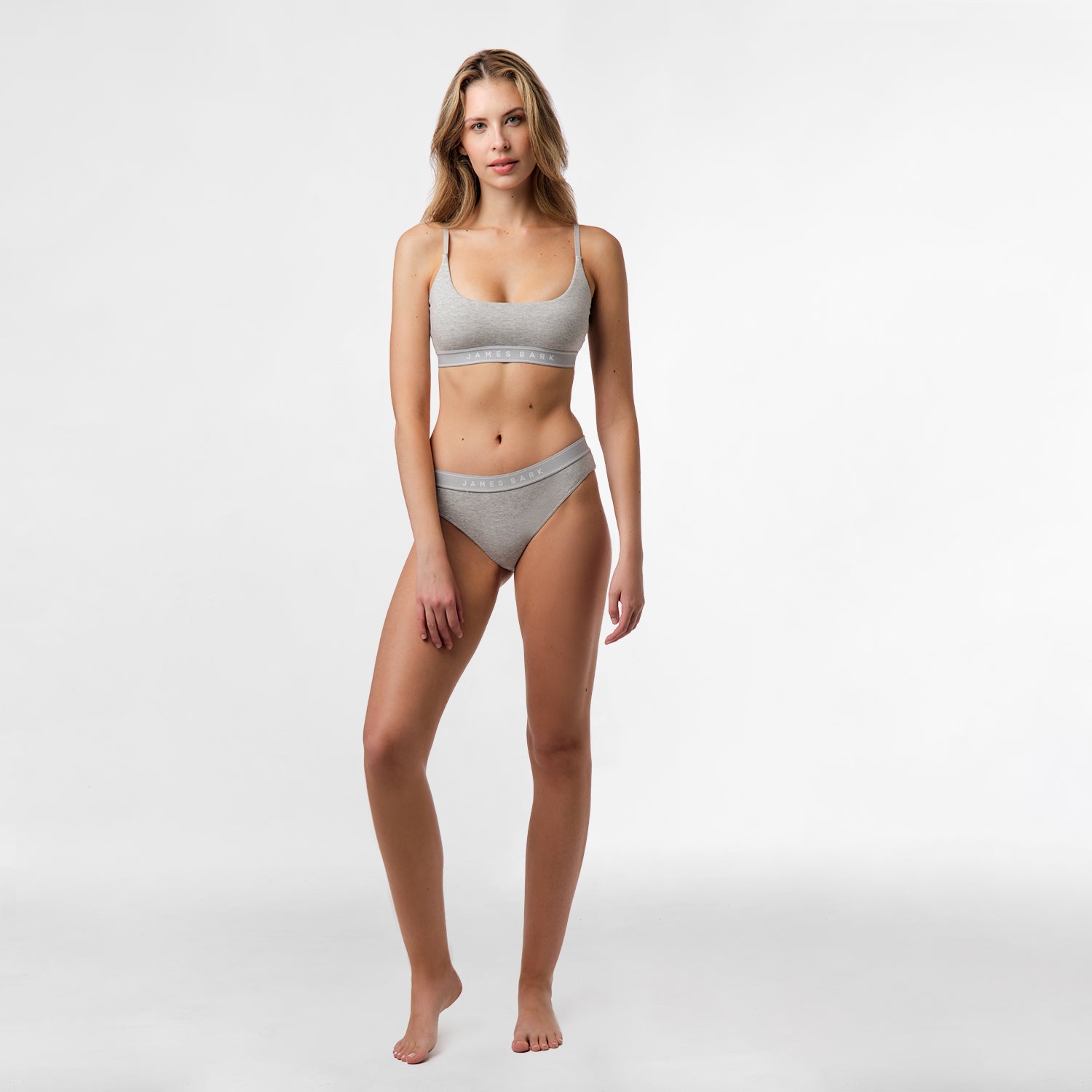 Full body view of a woman wearing the gray bralette and underwear set, standing in a neutral pose.