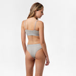 Front view of a woman wearing the matching gray thong and bralette set.
