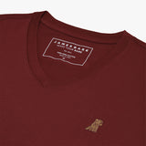 Close-up of the neckline and shoulder seam of the burgundy V-neck t-shirt, showing the stitching and fabric texture.