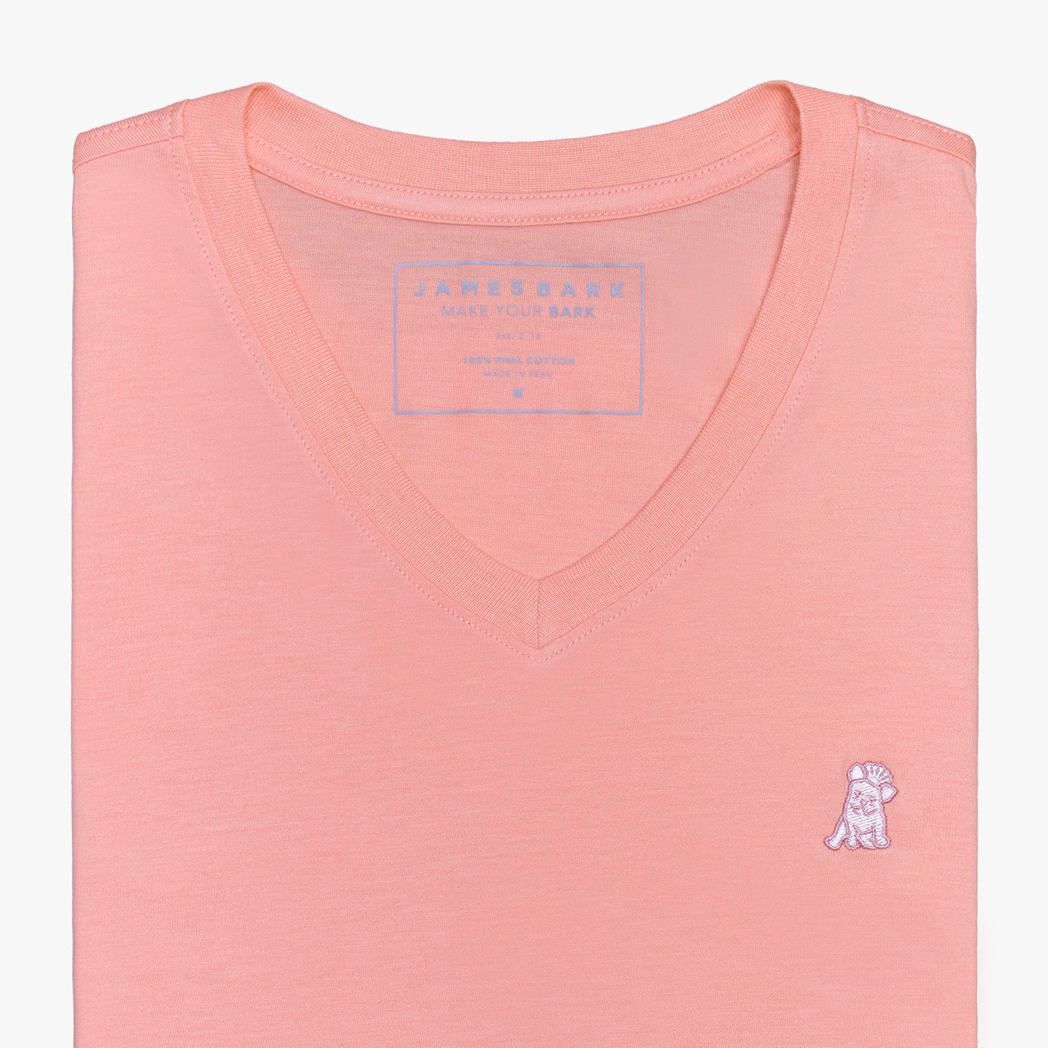 Close-up view of the coral V-neck t-shirt laid flat, highlighting the collar and small embroidered logo.