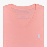 Close-up view of the coral V-neck t-shirt laid flat, highlighting the collar and small embroidered logo.